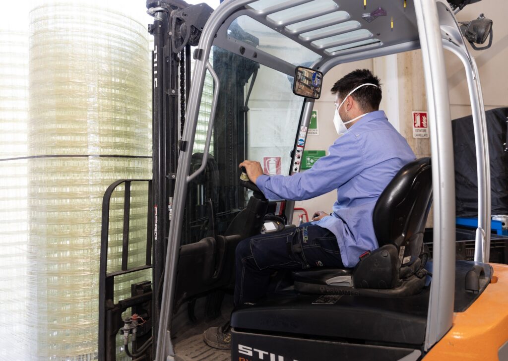 Operatore SystemCo alla guida del muletto con reti in vetroresina per edilizia e infrastrutture